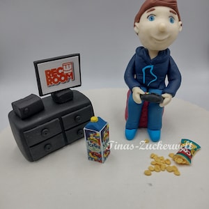 Könnte beinhalten: Eine Figur eines Menschen, der auf einem Sofa ein Videospiel auf einem Fernseher spielt, mit einer Schachtel Müsli und einer Tüte Chips. Der Fernsehbildschirm zeigt das Rec Room-Logo.