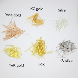 Op de afbeelding: Zes stapels kopspelden in verschillende kleuren: ros&eacute; goud, 14 karaat goud, goud, KC goud, zilver en KC zilver.