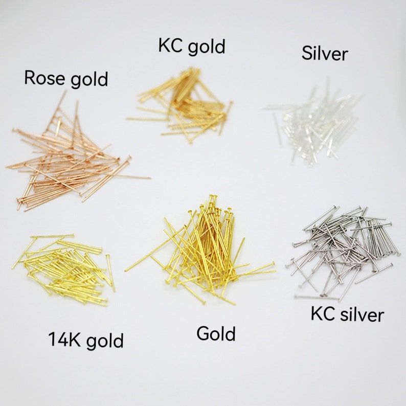 Op de afbeelding: Zes stapels kopspelden in verschillende kleuren: ros&eacute; goud, 14 karaat goud, goud, KC goud, zilver en KC zilver.