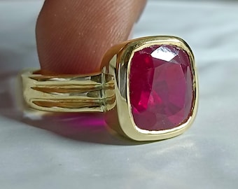 Ring met rode robijn: in een zilveren zetting met rand, geboortesteen van juli.