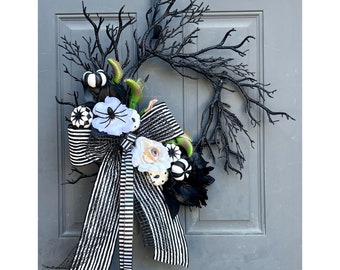 Corona de Halloween en blanco y negro: ramas brillantes y lazo de rayas