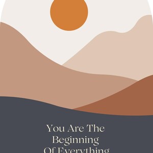 May include: Abstract art print featuring a minimalist landscape with layered mountains in shades of brown and beige, a dark blue base, and an orange sun. The text "You Are The Beginning Of Everything You Want" is at the bottom.
