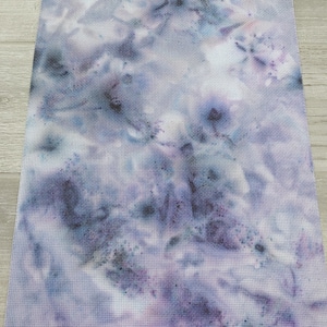 May include: A piece of white fabric with a tie-dye pattern in shades of purple and blue.
