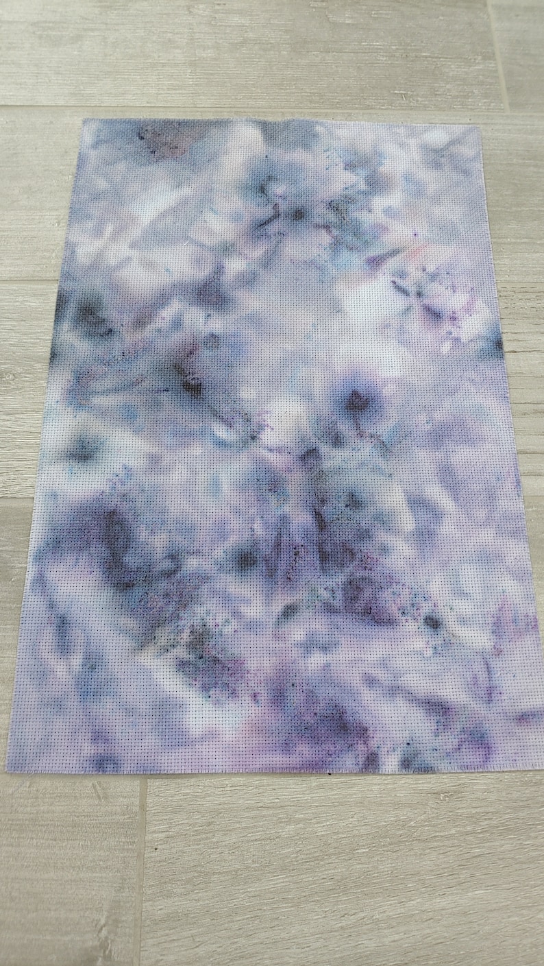 May include: A piece of white fabric with a tie-dye pattern in shades of purple and blue.