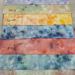 May include: Eight fabric swatches with tie-dye patterns in various colors, labeled with the words "Night", "Day", "Dawn", "Winter", "Autumn", "Summer", "Spring".