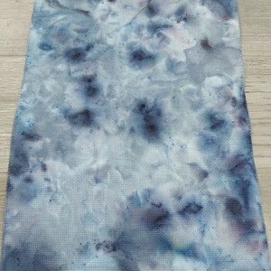 May include: A blue and white fabric with a tie-dye pattern. The fabric has a textured surface and is perfect for crafting projects.