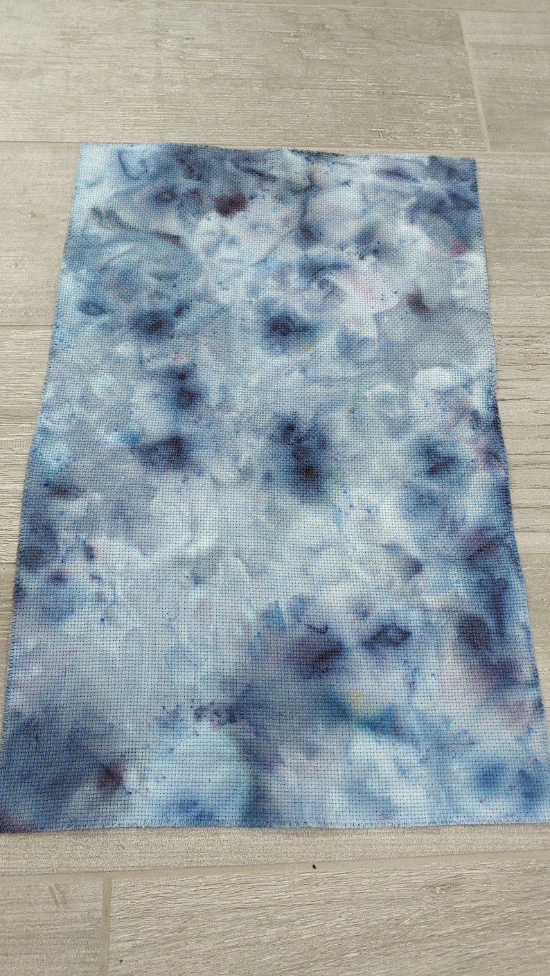 May include: A blue and white fabric with a tie-dye pattern. The fabric has a textured surface and is perfect for crafting projects.