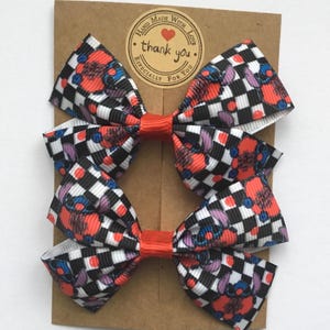 Red Nose Day patterned hair bows for toddlers, handmade with premium grosgrain ribbon and secure alligator clips or elastics.