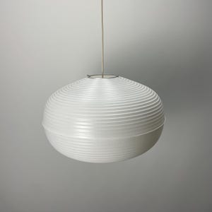 Puede incluir: Una l&aacute;mpara colgante esf&eacute;rica blanca con un dise&ntilde;o acanalado. La luz cuelga de un cable fino de color blanco roto y una fijaci&oacute;n met&aacute;lica circular. La l&aacute;mpara es de dise&ntilde;o moderno, adecuada para la iluminaci&oacute;n interior.