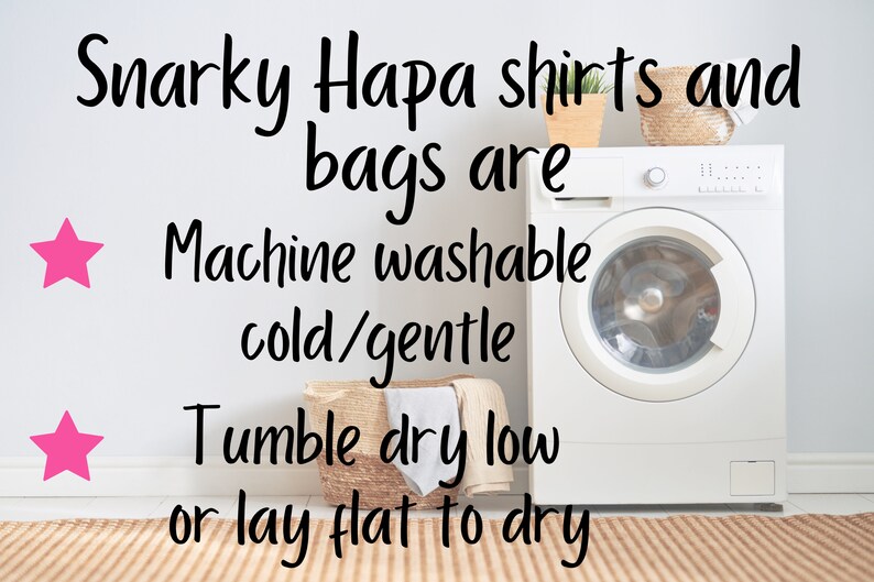 May include: A white washing machine with a white door and a silver knob. The text "Snarky Hapa shirts and bags are Machine washable cold/gentle Tumble dry low or lay flat to dry" is written on a white wall behind the washing machine.