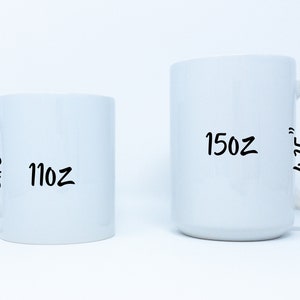 May include: Two white ceramic mugs with black handwritten text. The smaller mug is 11 oz and 3.75 inches tall. The larger mug is 15 oz and 4.75 inches tall.