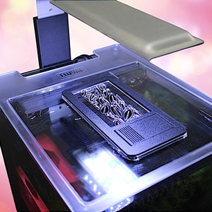 May include: A clear glass aquarium with a black lid and a black filter. The aquarium has a light fixture on the top and the word "Fluval" is printed on the lid.