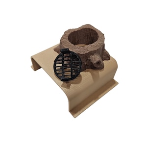 May include: A small, brown, wooden tree stump with a black metal grate on top. The stump is sitting on a light brown wooden base.