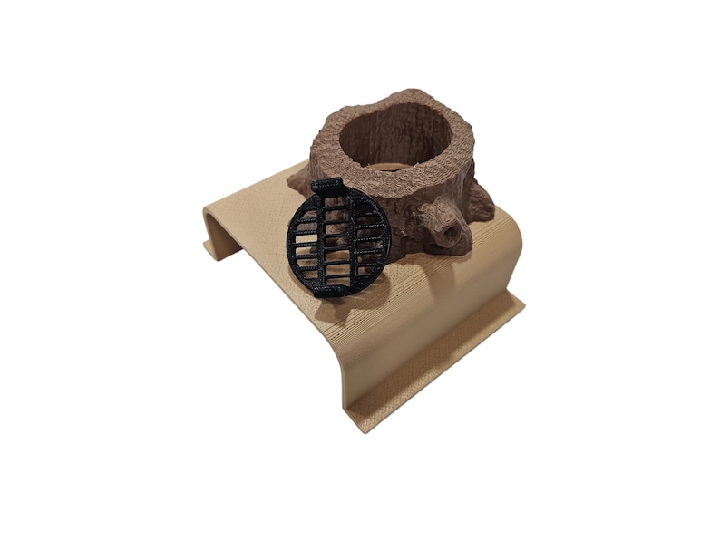 May include: A small, brown, wooden tree stump with a black metal grate on top. The stump is sitting on a light brown wooden base.