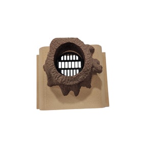 May include: A brown ceramic vent cover with a round, open, metal grate. The vent cover is designed to look like a tree trunk with a hole in it.