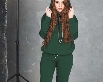 Solid green 2 piece full women tracksuit. Classic loose matching oversized hoodie and jogging pants. Cotton sweatpants and sweatshirt set
