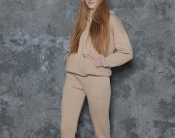 Cotton jersey tracksuit for women in sand colour. Cotton hoodie and cuffed joggers full two piece set. Warm sweatpants and hooded sweatshirt