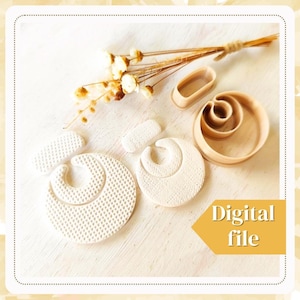 May include: A set of five wooden cookie cutters for making earrings. The cutters are in the shape of a circle, a crescent moon, a rectangle, and two different sized ovals. The cutters are on a white surface with a small bouquet of dried flowers.