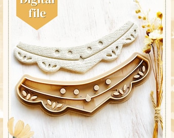 May include: Two brown plastic cookie cutters shaped like a necklace with a scalloped edge and decorative details. The top cutter is a lighter brown and has a more intricate design.