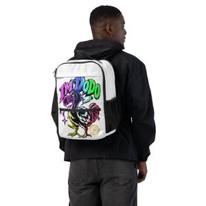 Könnte beinhalten: Ein weißer Rucksack mit einer bunten Grafik eines Dodo-Vogels und dem Schriftzug "I'M DODO" in leuchtenden, mehrfarbigen Graffiti-Buchstaben. Das Design enthält kleine Sternakzente und ein kreisförmiges goldenes Emblem auf der rechten Seite.
