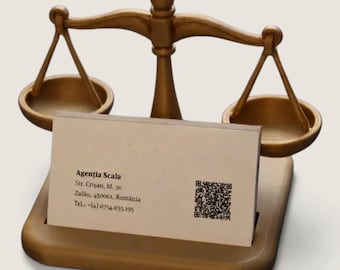 May include: A gold-colored metal scale of justice business card holder. A rectangular business card is inserted in the front, displaying the text: Agenția Scala, Str. Crișan, bl. 36, Zalău, 450061, România, Tel.: +(4) 0754.035.195 and a QR code.