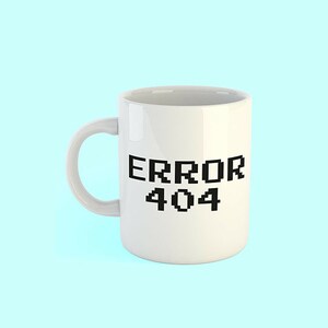 May include: White ceramic mug with black text that reads "ERROR 404" in a pixelated font.