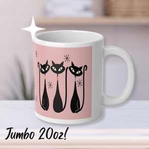 May include: White ceramic mug with a retro design featuring three black cat silhouettes with yellow eyes on a pink background. The mug has a large handle and the text "Jumbo 20oz!" at the bottom.