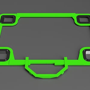 May include: A green plastic frame with four black rectangular cutouts and a handle. The frame is designed to hold a flat object, such as a picture or a sign.