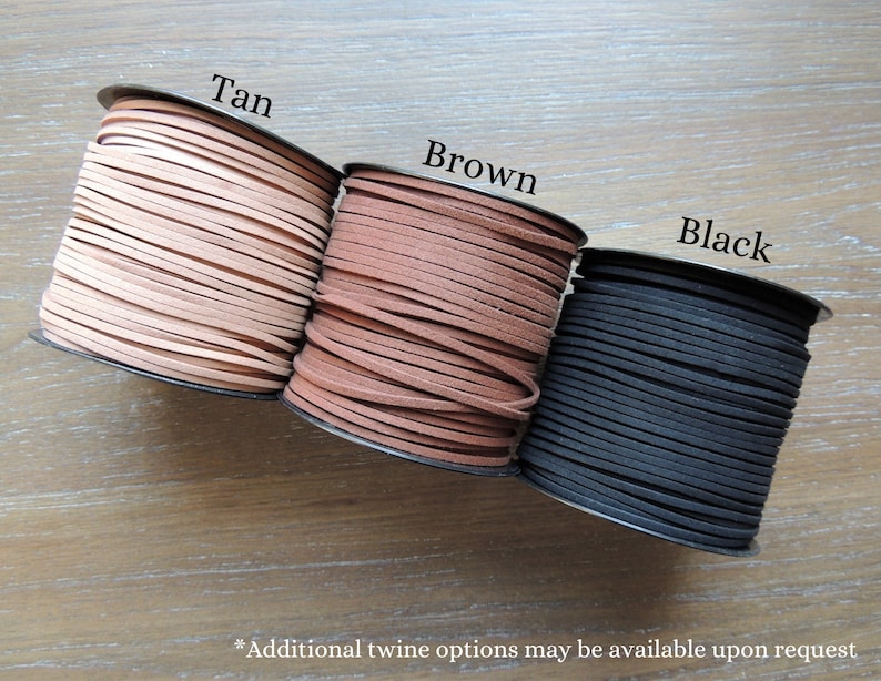 May include: Three spools of leather cord in tan, brown, and black. The spools are labeled with the colors.