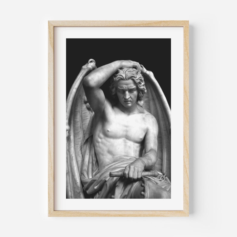 May include: Black and white photograph of a marble sculpture of a winged figure with a sorrowful expression. The figure is seated and has its head resting on its hand. The sculpture is set against a dark background.