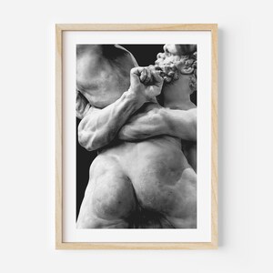 May include: Black and white framed print of a classical sculpture depicting two figures in a dynamic embrace. The sculpture showcases detailed musculature and a dramatic pose, set against a dark background.