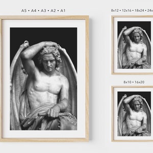 May include: Black and white photograph of a sculpture of a winged figure with a sorrowful expression. The figure is sitting with its head in its hand, and its wings are spread out behind it.