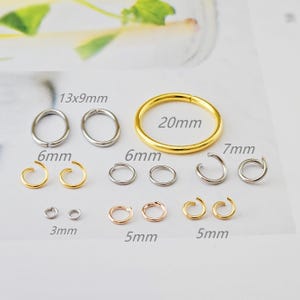 Könnte beinhalten: Eine Sammlung verschiedener kleiner Schmuckstücke aus Metall, darunter Ringe und Creolen. Die Größen sind in Millimetern angegeben und umfassen einen 20-mm-Goldring, 6-mm- und 7-mm-Creolen und kleinere Ringe. Der Schmuck ist in Silber-, Gold- und Roségoldtönen gehalten.