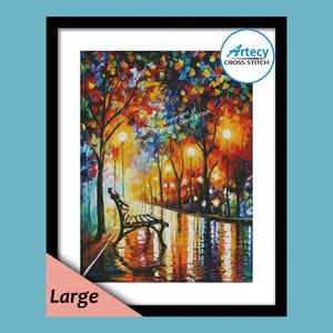 May include: A framed cross-stitch art piece depicting a vibrant, impressionistic night scene. The artwork features a park bench, streetlights, and colorful trees reflected in a wet surface. The frame is black, and the word "Large" is visible.