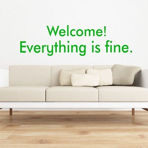 May include: White couch with three pillows in a living room with a white wall and green text that reads "Welcome! Everything is fine." The text is 16.5 inches by 60 inches.