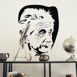 May include: A black and white silhouette of Albert Einstein's face, a silver telescope on a tripod, and a silver globe on a stand. The items are arranged on a wooden shelf.