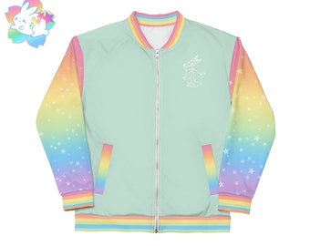 May include: A light green bomber jacket with rainbow sleeves and a white origami bunny design on the front. The sleeves have a gradient of pink, orange, yellow, green, blue, and purple with white stars. The jacket has a zipper closure and ribbed cuffs and waistband.