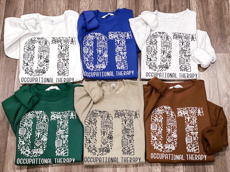 May include: Five different colored sweatshirts with the letters "OT" made up of small occupational therapy symbols. The text "Occupational Therapy" is printed below the letters.