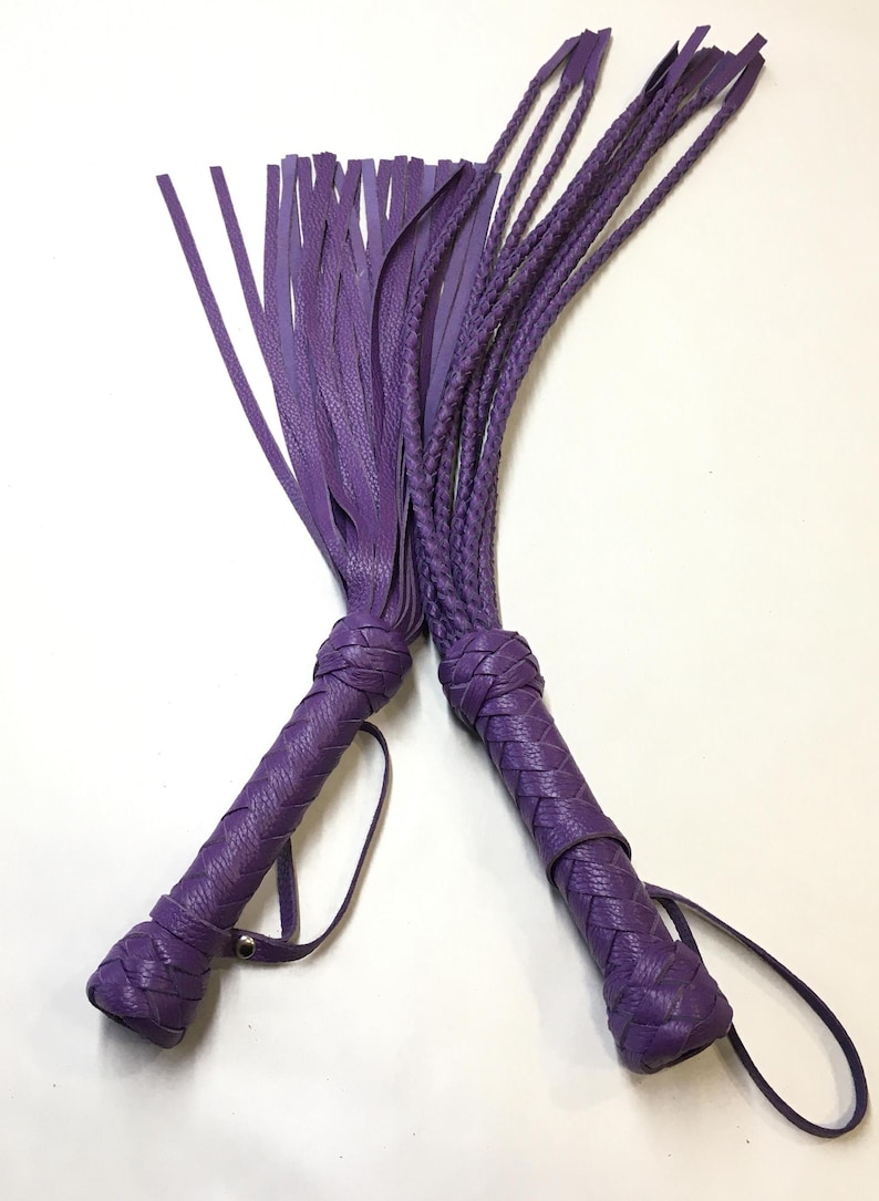 May include: Two purple leather whips with braided handles and fringe tassels.