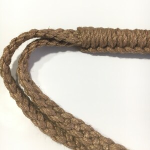 May include: A close-up of a thick, brown rope with a braided design. The rope is knotted at one end, creating a loop.