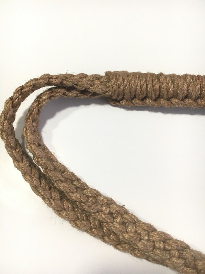 May include: A close-up of a thick, brown rope with a braided design. The rope is knotted at one end, creating a loop.