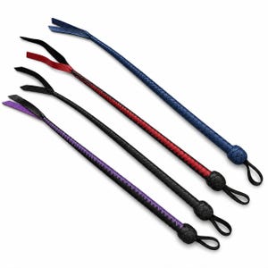 Puede incluir: Cuatro látigos de cuero en disposición diagonal. Los látigos son de varios colores: azul, rojo, negro y morado. Cada látigo tiene un mango trenzado y un lazo en el extremo. Las puntas de los látigos están divididas en dos o tres secciones.