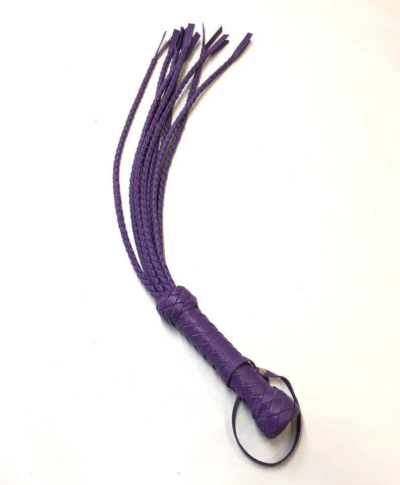 May include: A purple leather whip with a braided handle and a loop at the end.