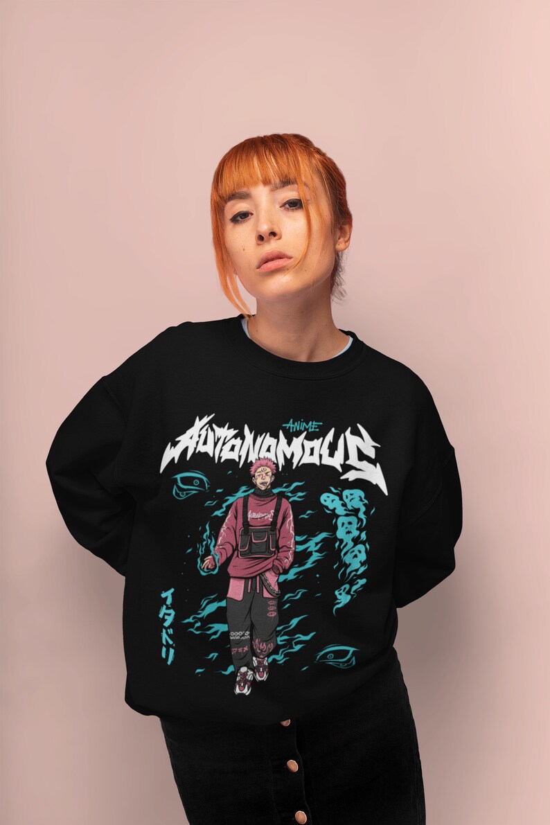 Peut inclure: Sweat-shirt noir avec un imprim&eacute; graphique d'un personnage d'anime v&ecirc;tu d'une tenue rose et noire sur un fond bleu et blanc. Le texte "ANIME AUTONOMOUS" est imprim&eacute; en blanc sur le sweat-shirt.