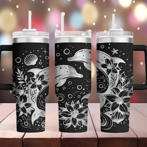May include: Three black stainless steel tumblers with a white design of dolphins, seashells, and flowers. Each tumbler has a black lid and a black handle.