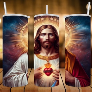 Puede incluir: Un vaso de acero inoxidable con una imagen colorida de Jesucristo con un corazón brillante. La imagen está rodeada por un halo de luz.