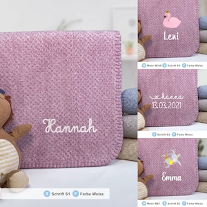 May include: A pink fleece baby blanket with white embroidery. The blanket is personalized with the name "Hannah".