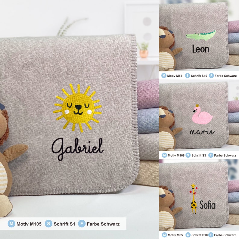 May include: A gray fleece blanket with a yellow sun and the name "Gabriel" embroidered in black. The blanket is folded and stacked with other blankets in different colors.