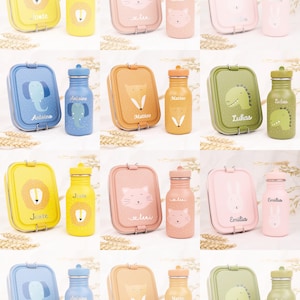 Op de afbeelding: Set van 10 kleurrijke lunchboxen en drinkflessen met dierillustraties en namen. Elke set bevat een rechthoekige lunchbox met een scharnierend deksel en een bijpassende drinkfles met een schroefdop. De lunchboxen en drinkflessen zijn gemaakt van metaal en hebben verschillende dierontwerpen, waaronder een leeuw, een kat, een vos, een olifant, een dinosaurus, een konijn en een hond.