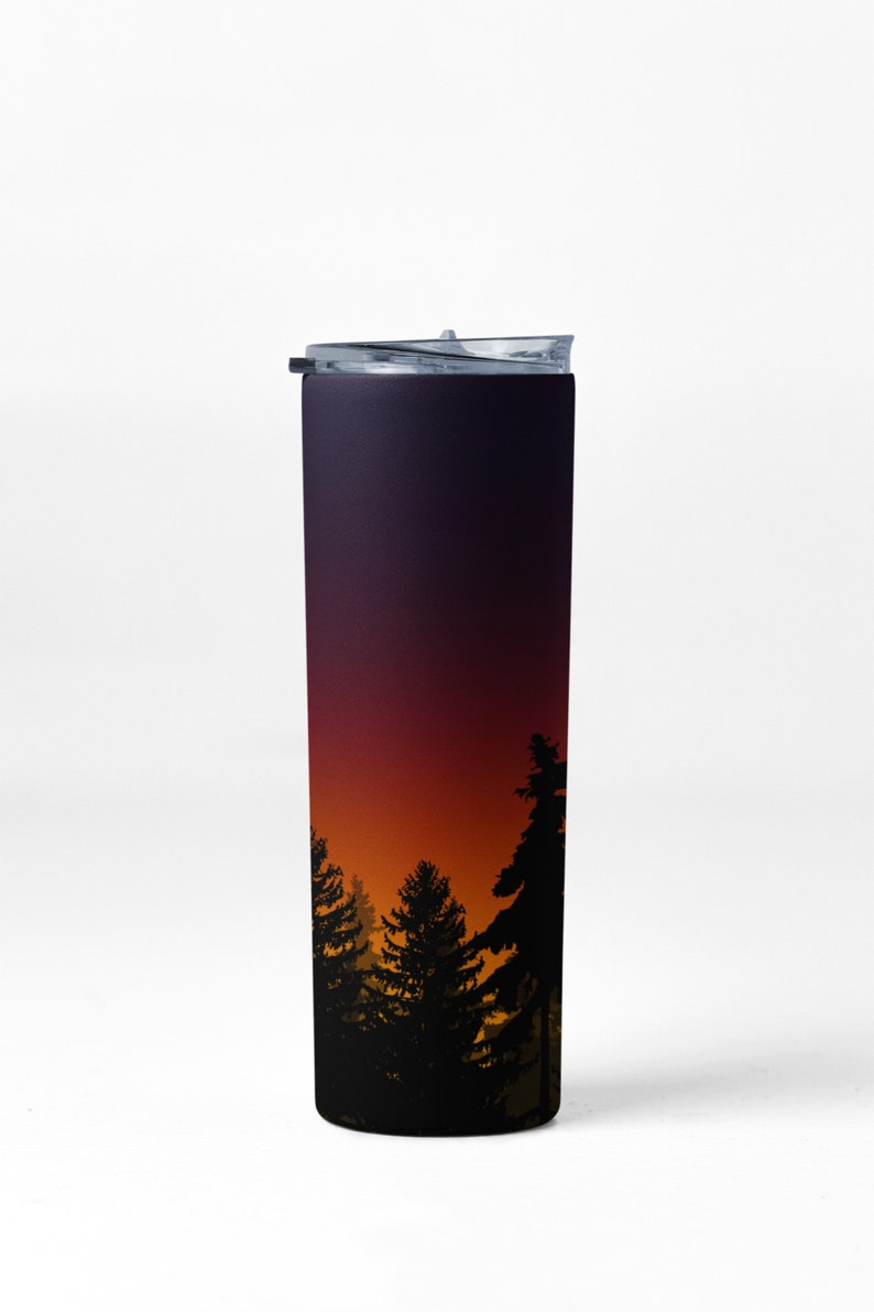 May include: A black and purple stainless steel tumbler with a clear lid. The tumbler features a sunset scene with silhouetted trees.